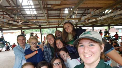Staff taking selfie with a cabin group all smiling at camera.