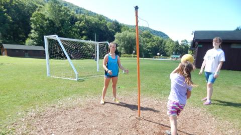 Three campers playing tether ball.