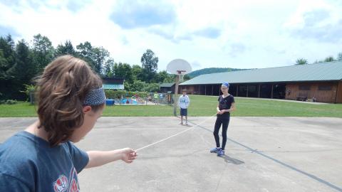 Campers on basketball court holding a string between them.