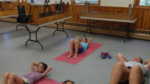Campers doing crunches on yoga mats.