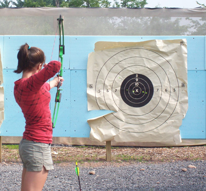 Girl shooting arrow at archery target - Help us hit our fundraising target