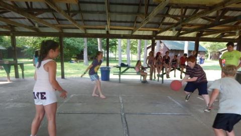 Youth playing four-square in the pavilion. 