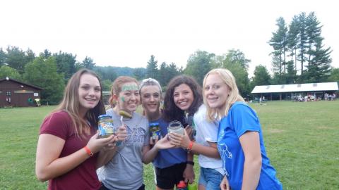 Five youth pose together with a jar of pickles. One youth has "pickles" written on their forehead and holds a pickle on a fork.