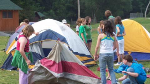 youth practice pitching tents before a camp-out.