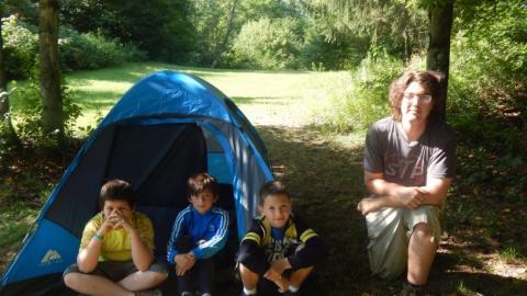 Youth participating in the backpacking program sit in front of their tent. 