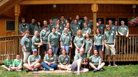 2008 camp staff standing together for a group photo on the porch of the Director's House.