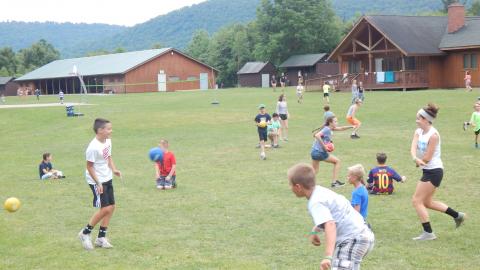 Campers scattered around the field playing dodgeball.