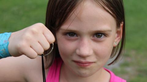Camper staring intensely into camera holding a keyring.