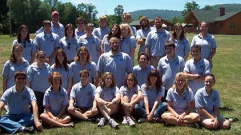 camp staff standing together in three rows for a group picture with matching gray shirts.