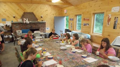 campers working on arts and crafts using paints 