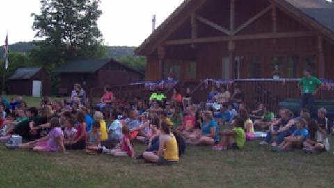 Campers and counselors sitting outside at camp. 