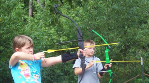 Two youth taking aim on the archery range.