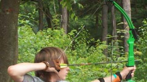 Youth shooting arrows as part of an archery program. 