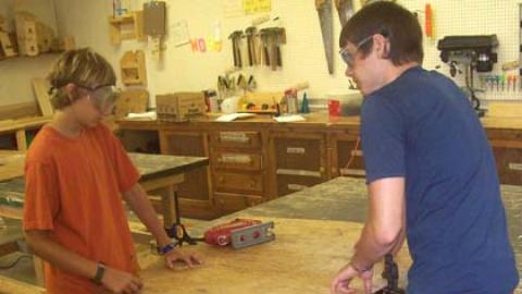 Youth work on a wood shop project together. 