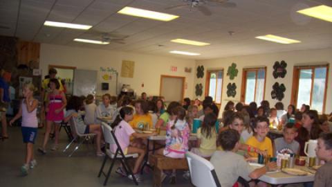 Campers and counselors seated together for a family style meal.