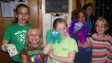 Youth showing sock puppet crafts. 