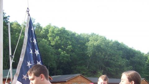 campers raising flag during the flag ceremony. 