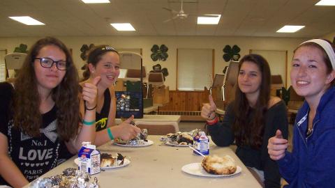 Youth eat bagels for breakfast in the dining hall. 