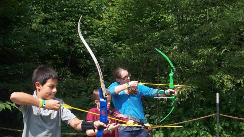 campers shooting bow and arrows 