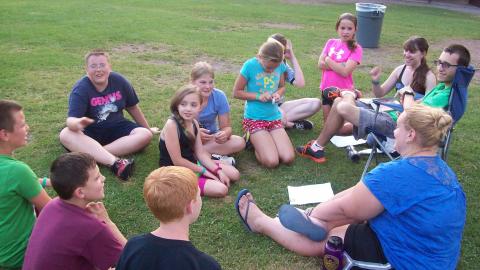 Campers sit in a circle with their counselor.