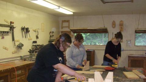 Youth work on wood working projects in the camp wood shop. 