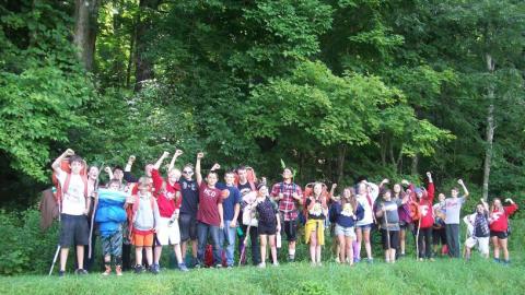 Youth participating in the backpacking program standing outside of the woods. 