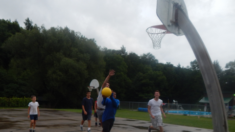 Youth making a shot during a game of basketball.