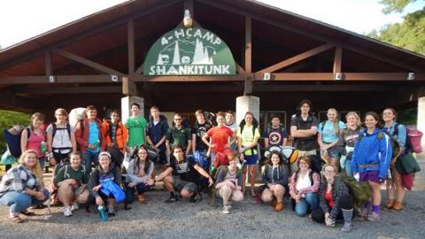 The camp backpacking group pose for a photo in front of the 4-H Camp Shankitunk sign. 