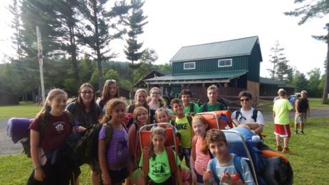 Campers holding backpacking gear. 