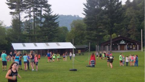 Youth playing games in the field at camp. 