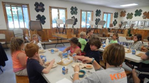 Day campers eat lunch in the dining hall. 