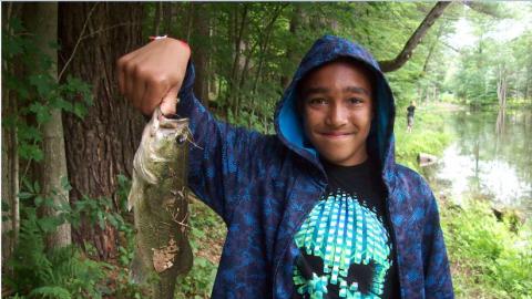 Camper holds up a freshly caught fish. 
