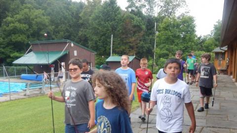 Campers walking with their fishing poles in hand. 