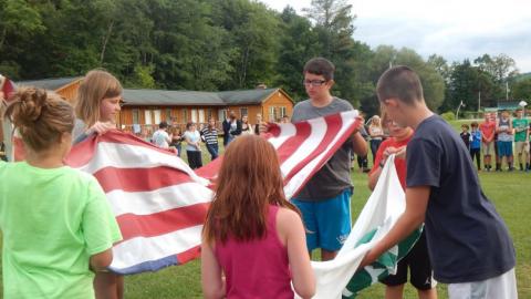 Youth folding the flags that have been lowered. 
