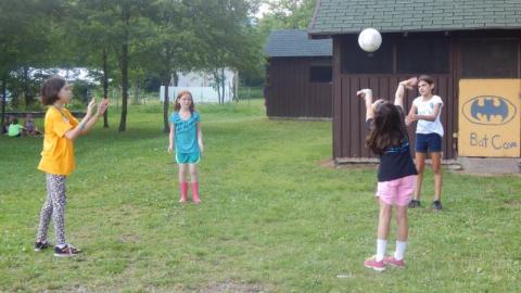 Youth throwing a ball between one another in a circle. 