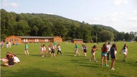 campers play outside in the field at camp during an ice breaker