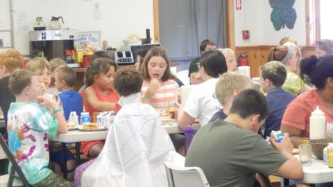 Campers sit down to have a meal in the dining hall. 