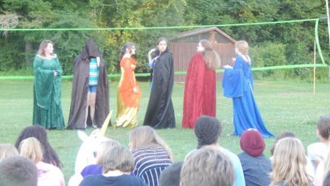 Youth wearing robes perform a skit for the campers. 
