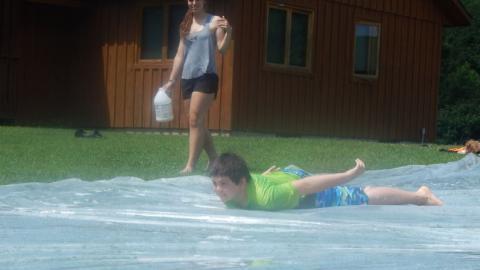 Camper goes down a giant slip and slide. 