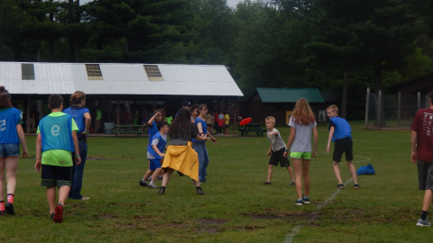 Two teams playing frisbee in the field.