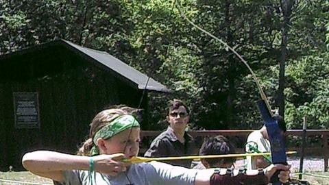 campers shooting bow and arrows 