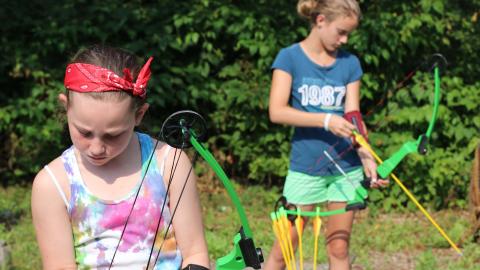 campers loading arrow into bows