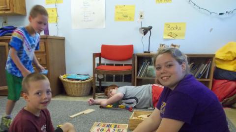 day campers sitting on floor doing puzzles with counselor