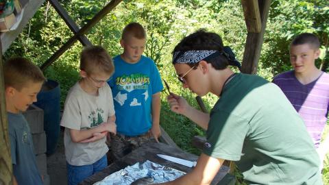 campers and counselor filleting a freshly caught fish