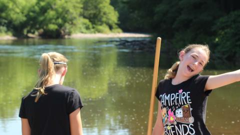 Youth searching for objects in stream with nets