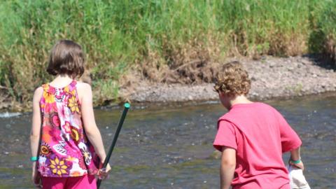 campers fishing in stream with net