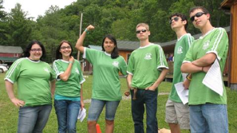 Counselor in training participants stand together in matching camp shirts before campers arrive for the week.