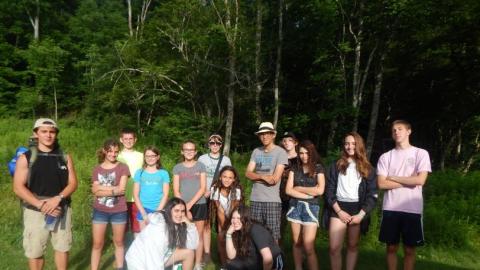 Campers pose for a photo outside of the woods. 