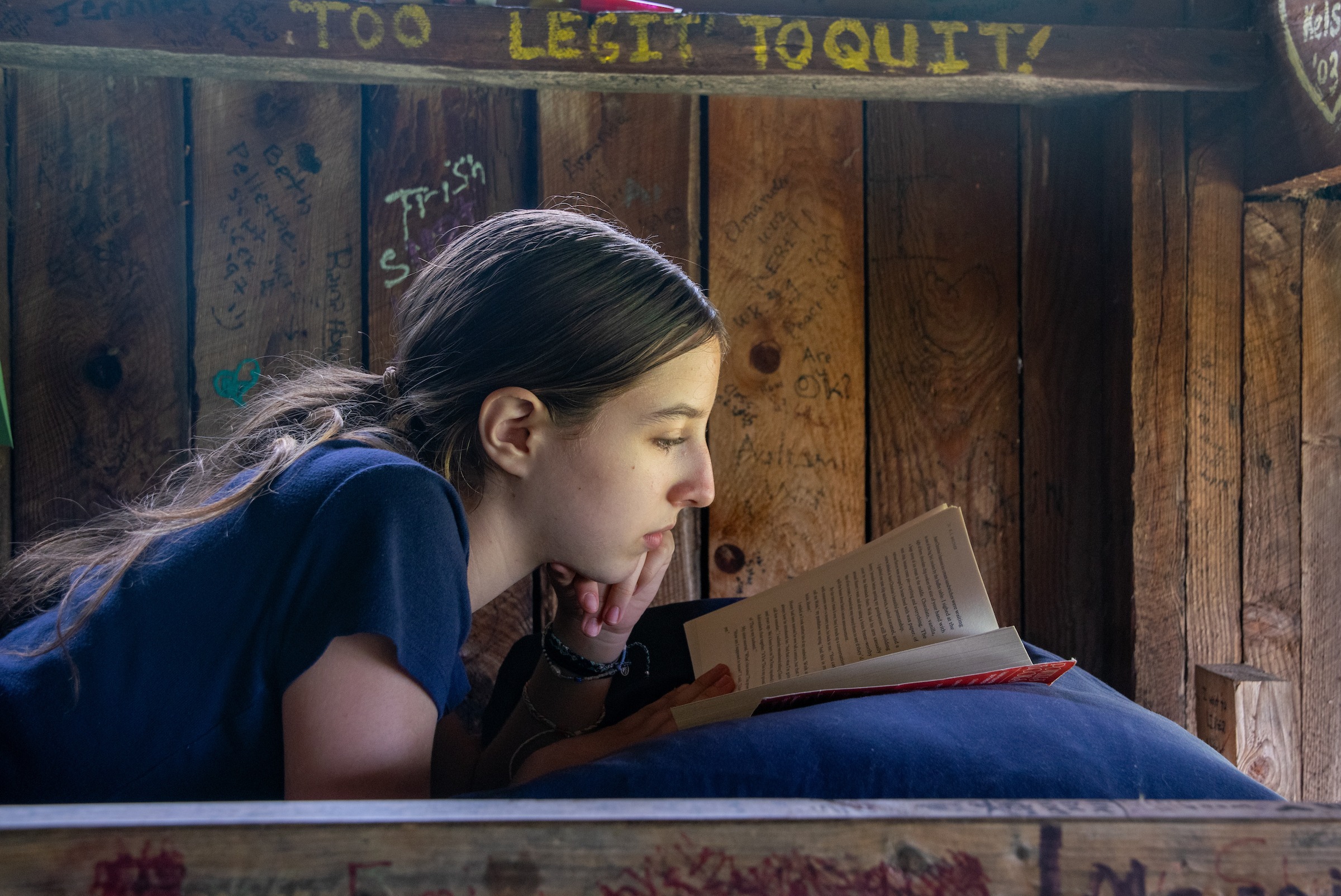Girl reading a book in her bunk bed