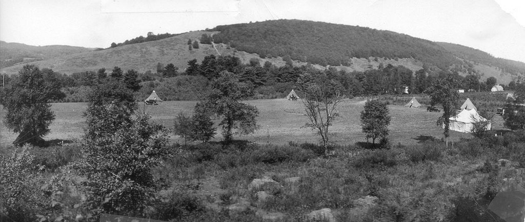Old back and white photo of original camp with rustic tents